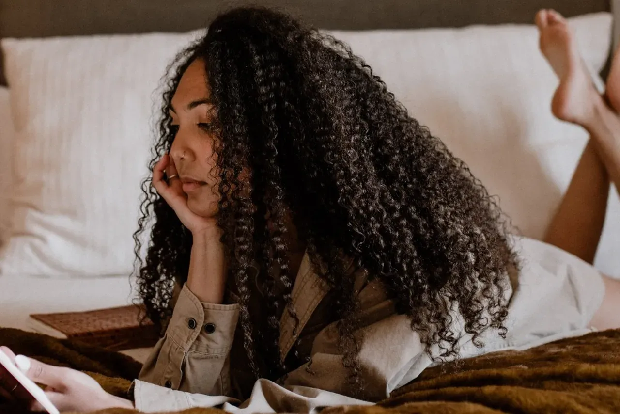 Depressed woman on bed wondering if she should start medication for depression